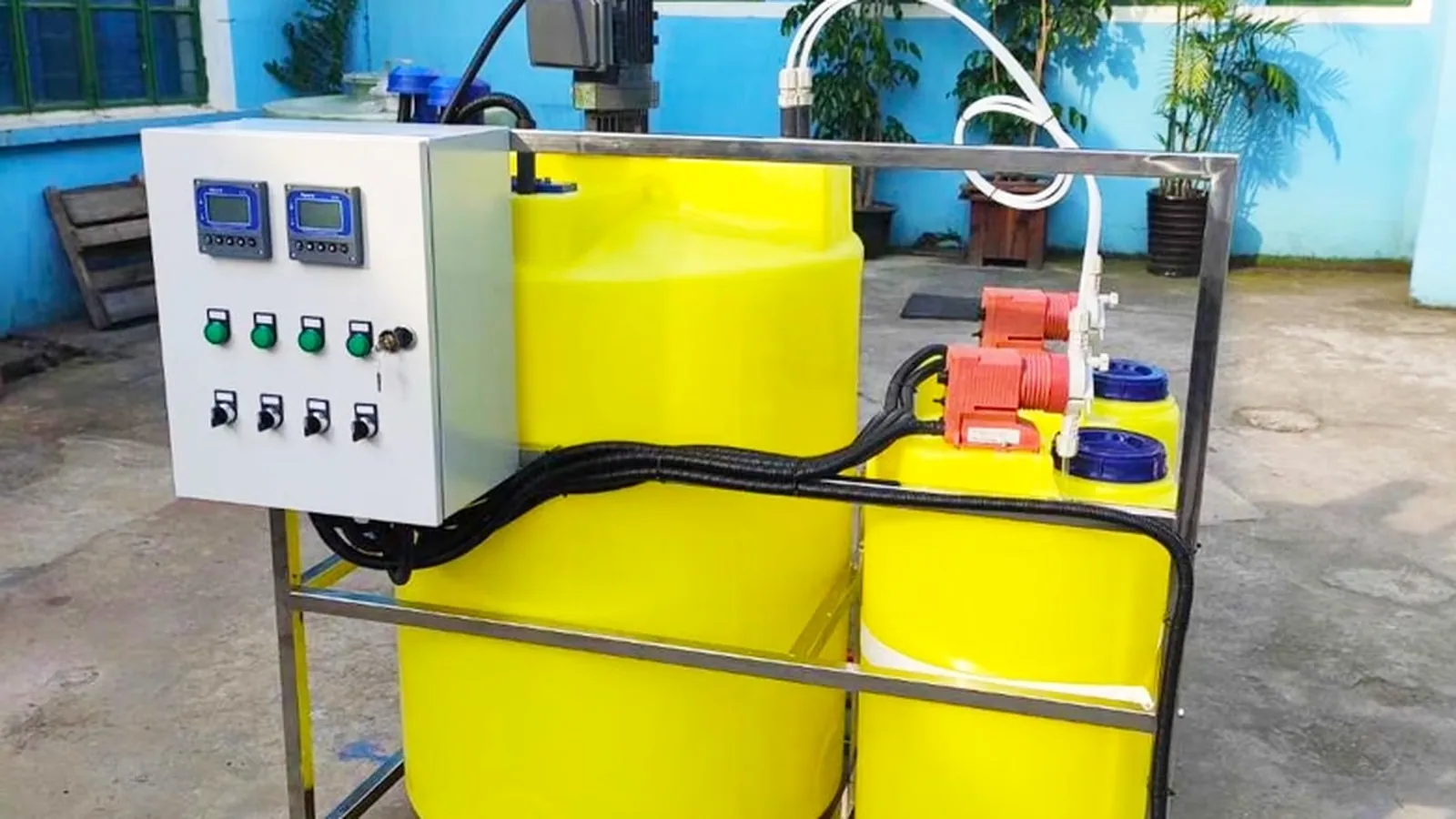 Chemical dosing skid with day tank, control panel and metering pump at a treatment site