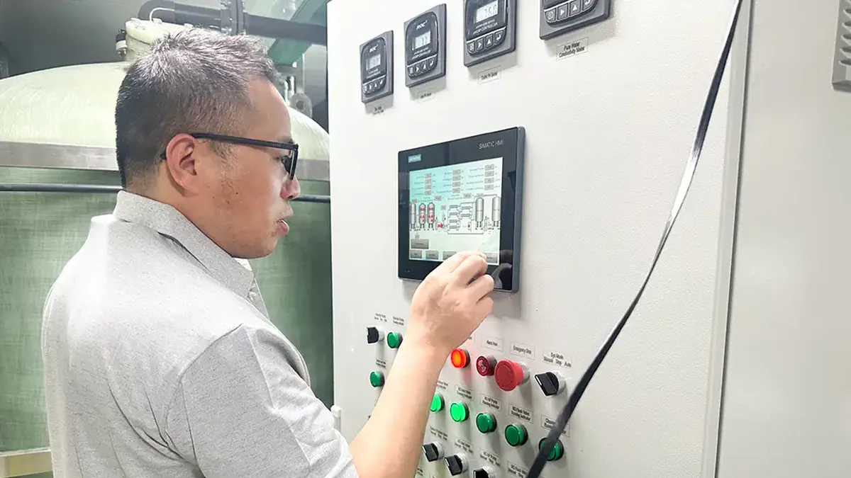 Engineer adjusting a dosing pump control panel with process flow diagram